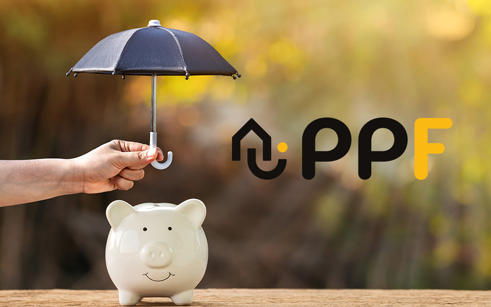 Main tenant un parapluie au-dessus d’une tirelire en forme de cochon avec le logo PPF